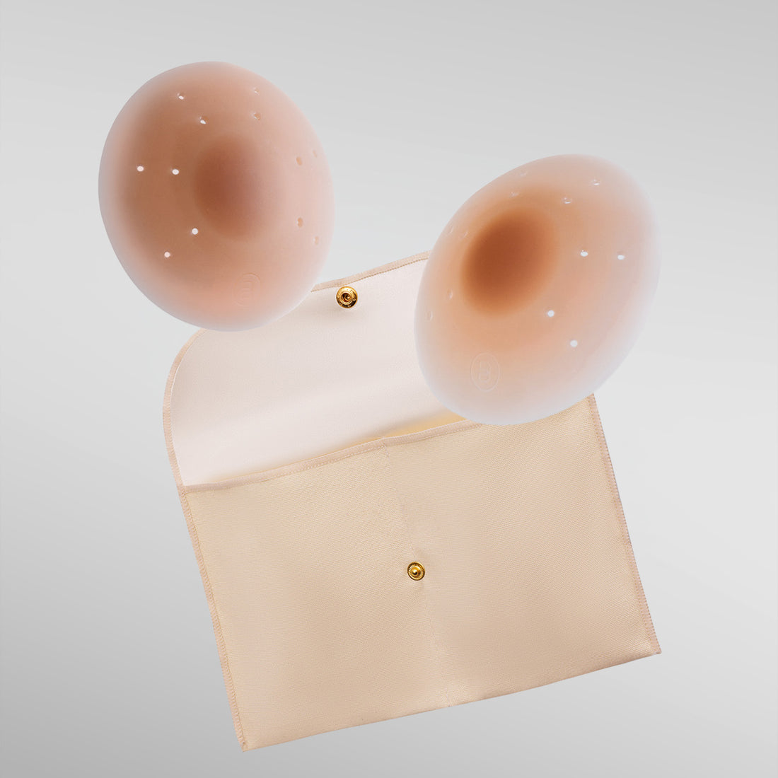 Pair of Essential petals in tan shade with breathe points and adhesive-free center and storage pouch.