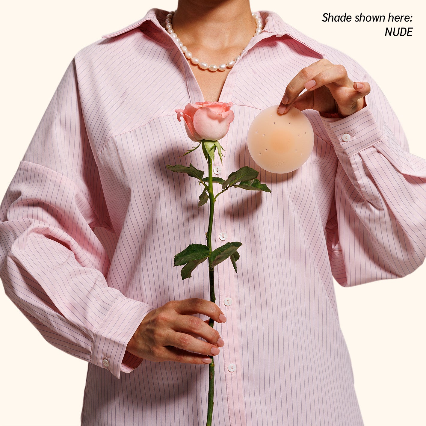 Woman in pink shirt showing invisible coverage with Essential petals